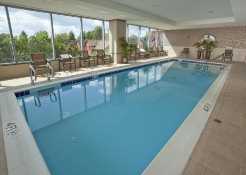 a large swimming pool in a hotel with windows at Embassy Suites Buffalo in Buffalo