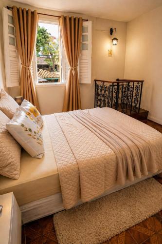 a bedroom with a large bed with a window at Casa Completa No Centro Para Famílias e Grupos Até 9 Hospedes Com Garagem in Ouro Preto