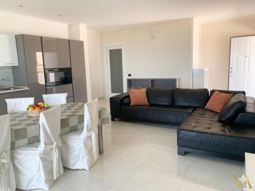 a living room with a couch and a table at VILLA ARCANGELO Lo in Mandatoriccio Marina