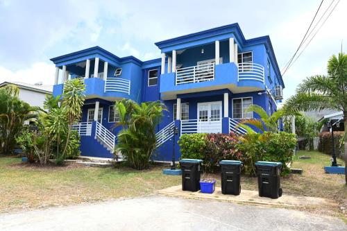a blue house with trash cans in front of it at Best E Villas St Silas St James in Saint James