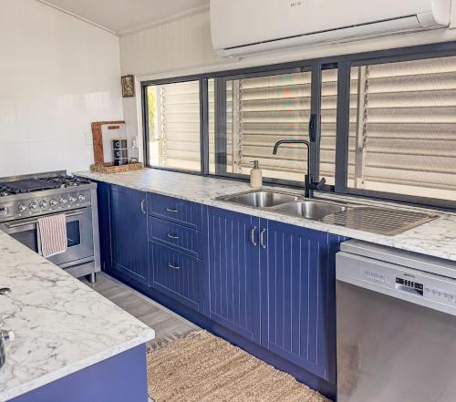 a kitchen with blue cabinets and a sink at Panacea Rising in Yeppoon