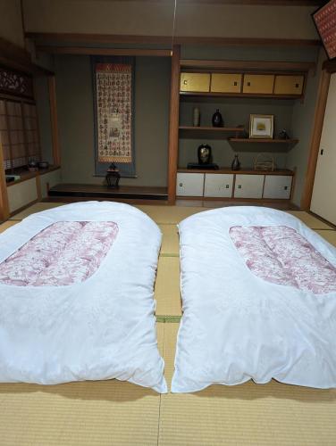 two beds in a room with white pillows at Y House in Kurashiki
