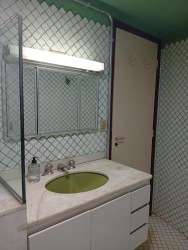 a bathroom with a green sink and a mirror at Casa Duque in Ribeirão Preto