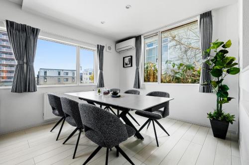 a dining room with a table and chairs and windows at Mist in Sapporo