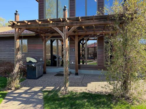 a wooden pergola in front of a house at FC River Retreat in Wilson