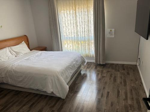 a bedroom with a bed and a large window at Comfortable room O in Kitchener