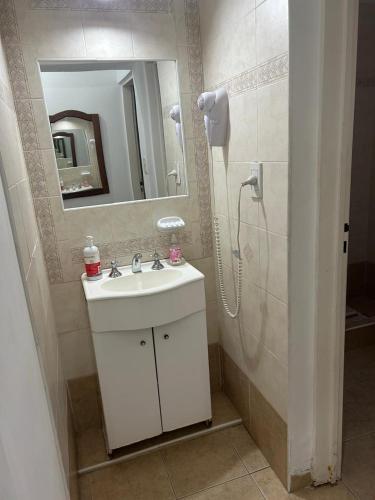 a bathroom with a sink and a shower with a mirror at Piscoyaku Apart-Amplio parque con cancha de padel, voley y futbol in Potrero de los Funes