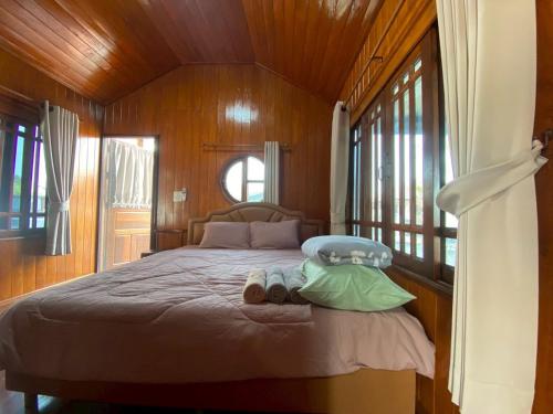 a bedroom with a bed with two slippers on it at Gun Eng Resort กันต์เองรีสอร์ท in Ban Nong Nam Sang