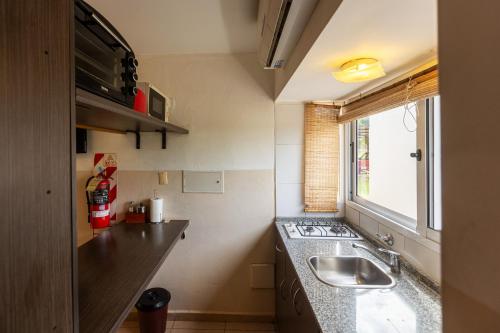 a small kitchen with a sink and a window at La Agustina Complejo Apart in Valle Grande