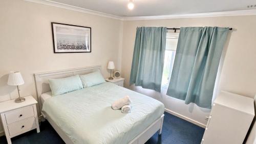 a small bedroom with a bed and a window at Family Beachside Shack in Geographe