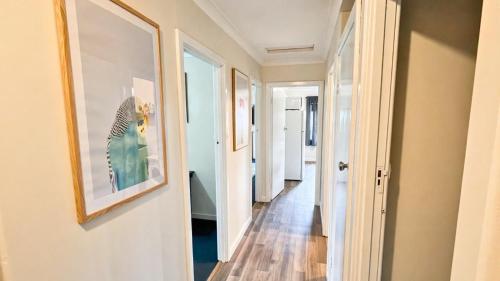 a hallway with paintings on the walls at Family Beachside Shack in Geographe