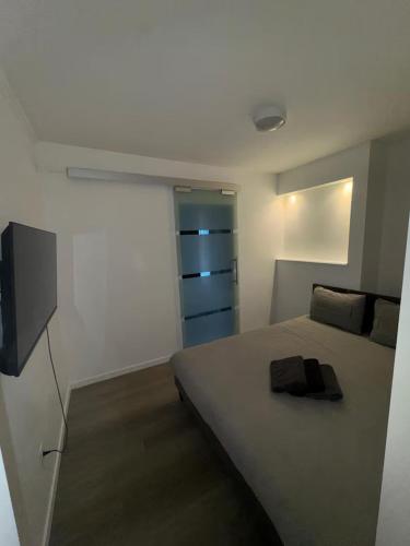 a bedroom with a bed and a television in it at Chic Design and Modern Comfort - 1BR with Sofa Bed in Liège