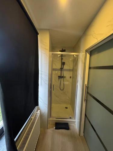 a small walk in shower in a small room at Chic Design and Modern Comfort - 1BR with Sofa Bed in Liège