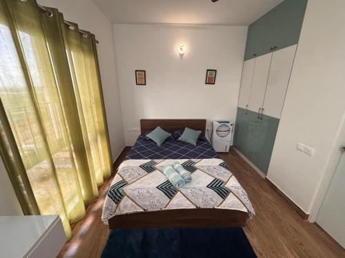a bedroom with a bed with a quilt on it at Podcast House in Chikmagalūr