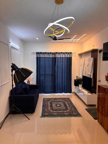 a living room with a couch and a chandelier at Podcast House in Chikmagalūr