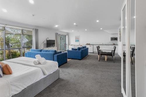 a bedroom with a blue bed and a table and chairs at Bay View - Lounge Lovers in Lorne
