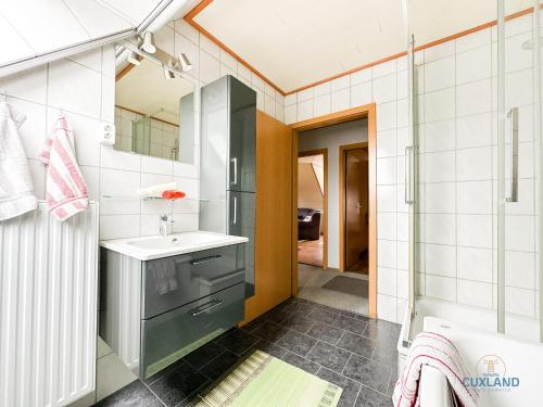 ein Badezimmer mit Waschbecken und Dusche in der Unterkunft Medemblick in Ihlienworth