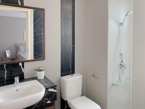 a bathroom with a toilet and a sink and a mirror at The Landmark By Katana Penang in Tanjong Tokong
