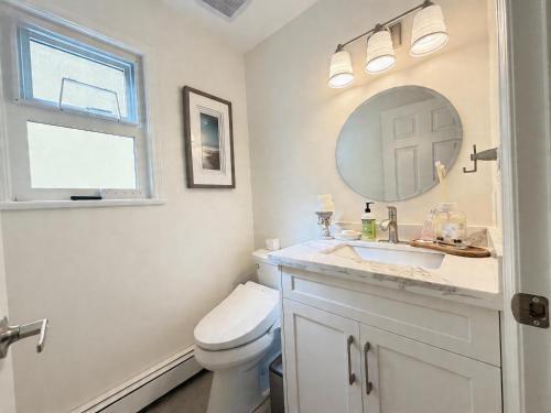 a bathroom with a toilet and a sink and a mirror at Vancouver Lucy House in Vancouver