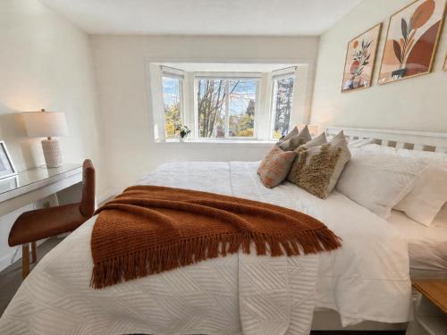 a bedroom with a white bed with a blanket on it at Vancouver Lucy House in Vancouver