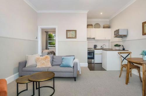 a living room with a couch and a kitchen at Centennial Cottage 1 - 'Boorool' in Bowral