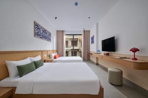 a hotel room with two beds and a television at Solla Hotel in Ninh Binh
