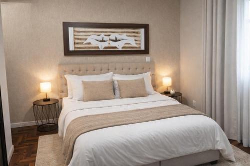 a bedroom with a large white bed with two lamps at Suíte Executiva - Climatizada in Erval dʼOeste