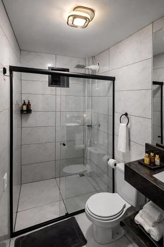 a bathroom with a shower with a toilet and a sink at Suíte Executiva - Climatizada in Erval dʼOeste