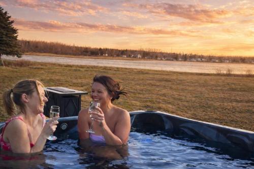 two women in a hot tub with glasses of wine at Waterfront Cottage ''The Dream'' with Hot Tub, near Parlee Beach in Shediac