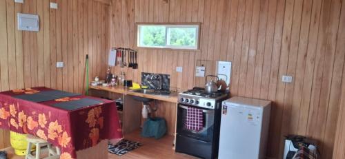 a kitchen with a counter and a stove and a table at Luz de mareas in Ancud