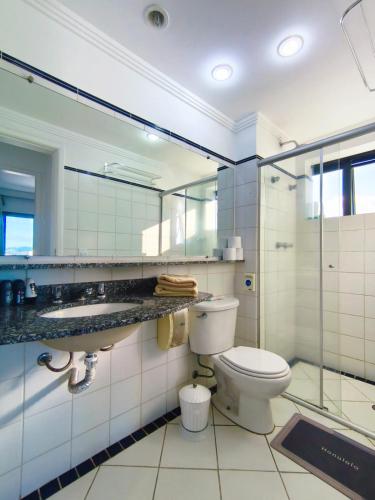 a bathroom with a toilet and a glass shower at BLUE HAT - Apart Hotel in Mogi das Cruzes