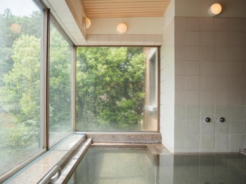 a bathroom with a tub and a large window at Takarazuka Washington Hotel in Takarazuka