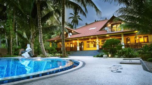 a house with a swimming pool in front of a house at Camplung Beach Family Villa and Farmstead in Tejakula