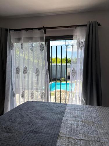 a bedroom with a bed and a view of a pool at La Delfina in Chacras de Coria