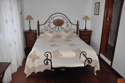 1 dormitorio con 1 cama con edredón blanco en Casa Rural de 1945 Dos Plantas Patio Y Barbacoa, en La Frontera
