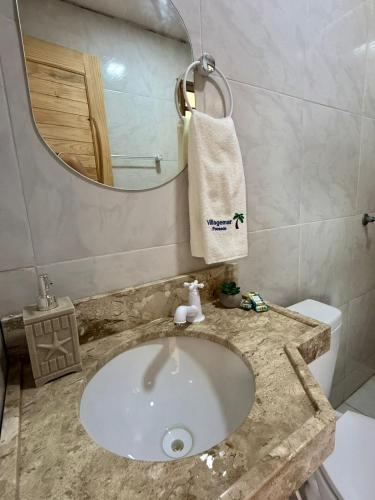 a bathroom with a sink and a mirror at Pousada VillageMar in Cascavel