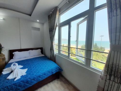 a bedroom with a bed and a large window at Khách sạn Đông Tây Quy Nhơn in Quy Nhon