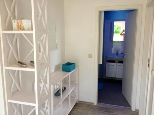 a room with a white book shelf and a sink at Ferienwohnung mit Kamin am Achterwasser in Lütow in Lütow