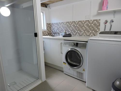 a kitchen with a washing machine and a sink at Sunrise on the Esplanade in Yeppoon