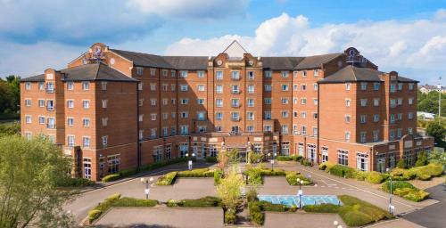 a large red brick building with a courtyard at DoubleTree by Hilton Dartford Bridge in Dartford