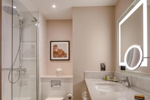 a bathroom with a shower and a sink and a mirror at DoubleTree by Hilton Dartford Bridge in Dartford