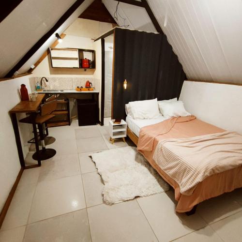 a bedroom with two beds and a desk and a sink at Chalés & glamping primitivo Búzios in Búzios