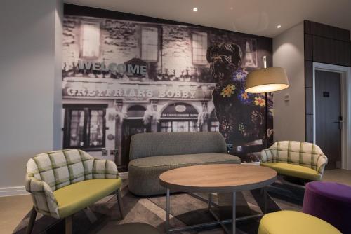 a living room with chairs and a wall with a mural at Hampton By Hilton Edinburgh West End in Edinburgh