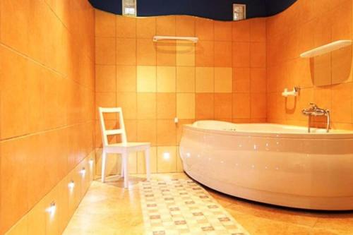 a bathroom with a white chair and a tub at Comfortable holiday home, summer pool in Łeba