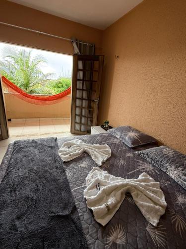 a bed in a room with a large window at Pousada VillageMar in Cascavel