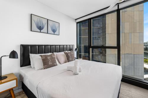 a bedroom with a large white bed with a large window at CBD RiverView 2Bed Apt Kingbed at Tallest building in Brisbane