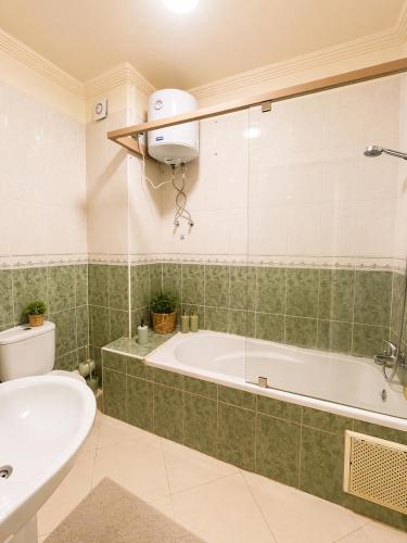a bathroom with a tub and a toilet and a sink at Résidence El Harti in Marrakesh