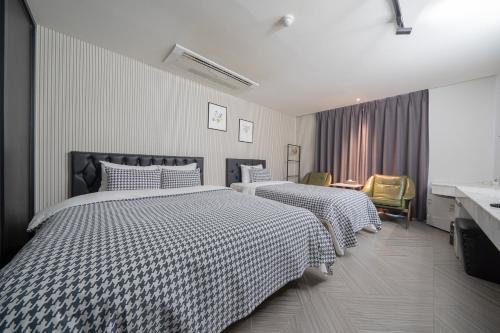 a hotel room with two beds and a desk at 동대문 벨루스 호텔 in Seoul
