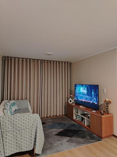 a living room with a flat screen tv and a couch at Depa en Comas in Lima