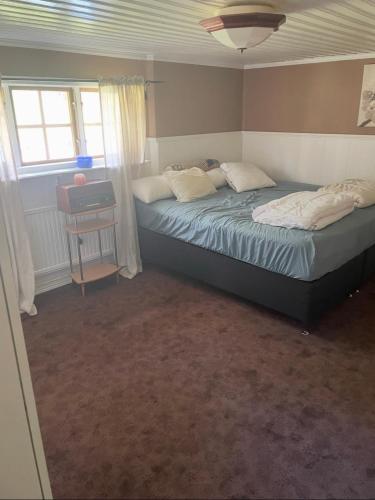 a bedroom with two beds and a table and windows at Nature & Tranquility in Örebro